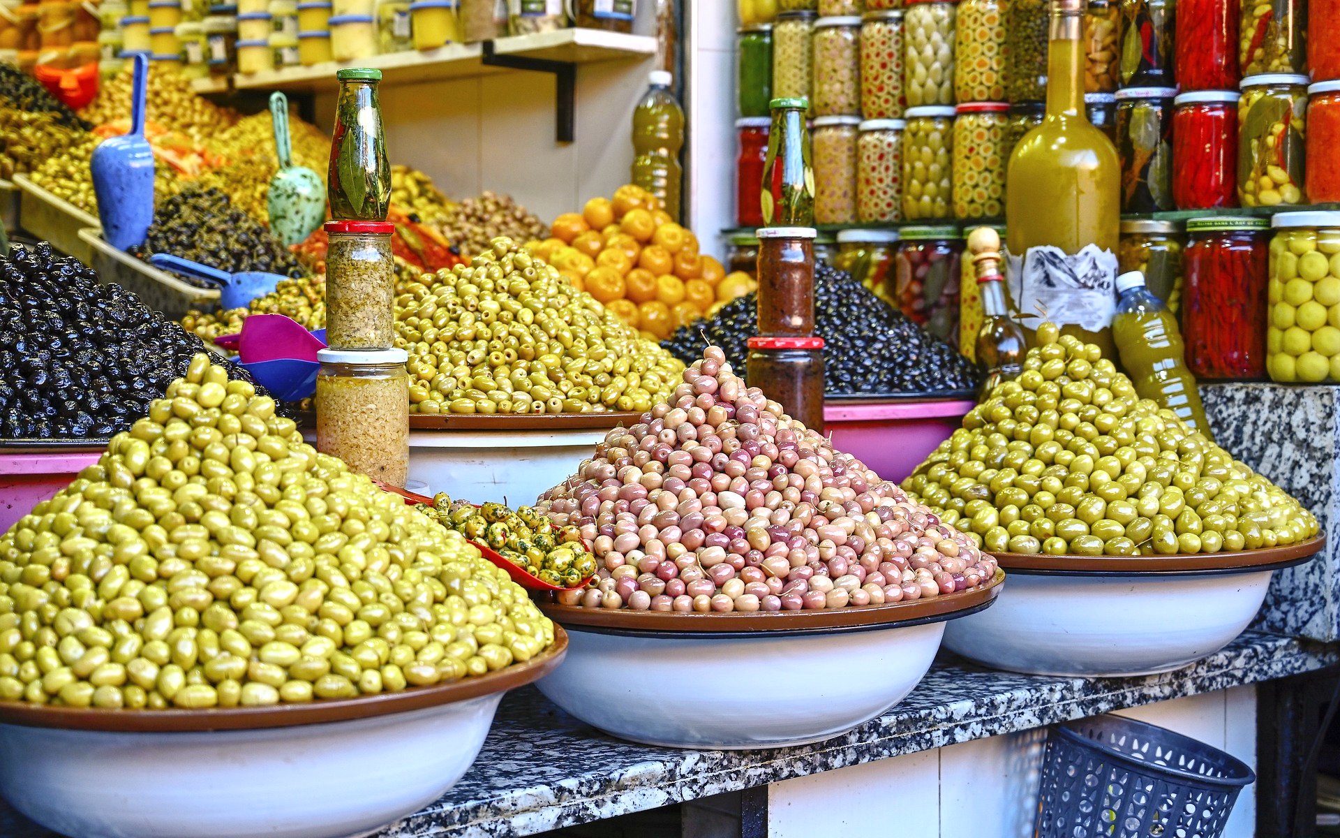Olives and preserved goods displayed in Marrakech souk during guided tour.
