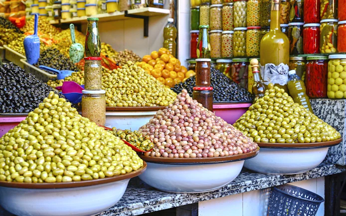 Olives and preserved goods displayed in Marrakech souk during guided tour.