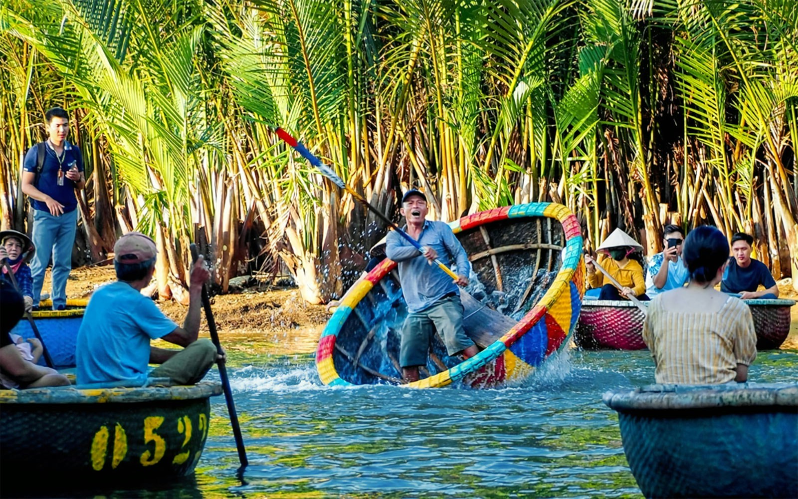 People enjoying a vibrant coconut basket boat ride through lush palm trees in Vietnam.