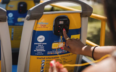 Tourist using audio guide on Yellow Bus during Lisbon Hop-on Hop-off Bus Tour.
