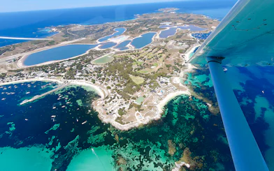 Aerial view of Rottnest Island's coastline and salt lakes, featuring turquoise waters.