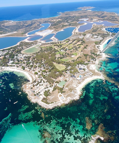 Aerial view of Rottnest Island's coastline and salt lakes, featuring turquoise waters.