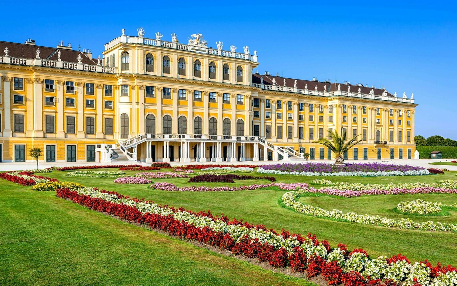 Schönbrunn Palace facade with vibrant gardens, Vienna.