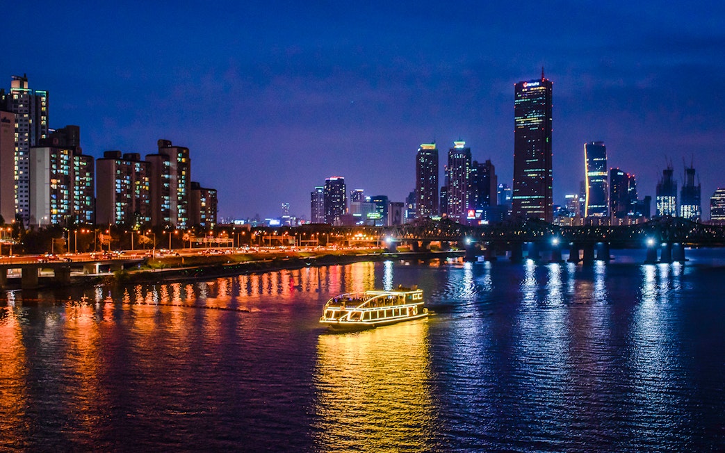 E-land ferry cruising on Han River with Seoul skyline in the background.