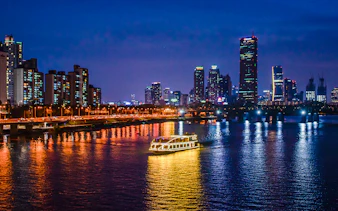 E-land ferry cruising on Han River with Seoul skyline in the background.