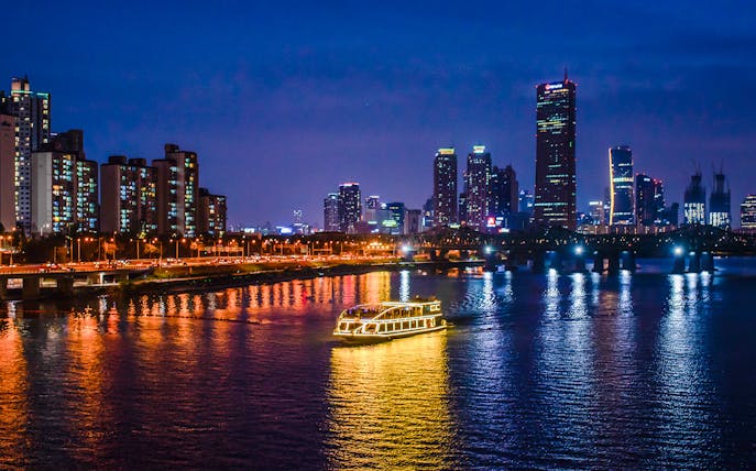 E-land ferry cruising on Han River with Seoul skyline in the background.