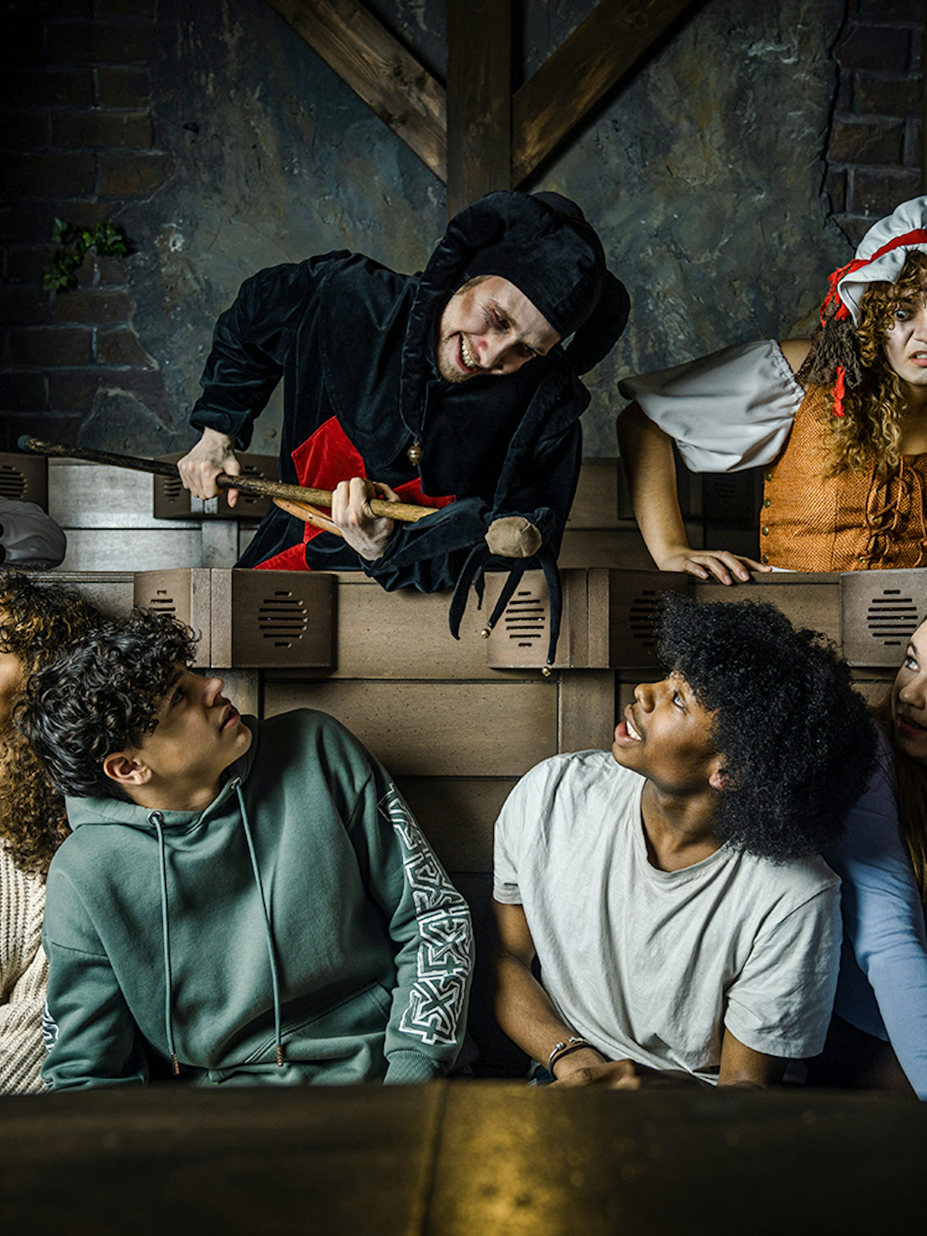 Guests interacting with actors in medieval costumes at the Amsterdam Dungeon.