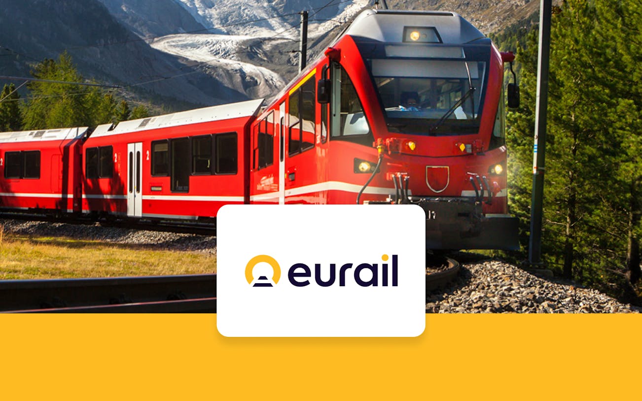 Red train traveling through mountainous landscape with Eurail logo.
