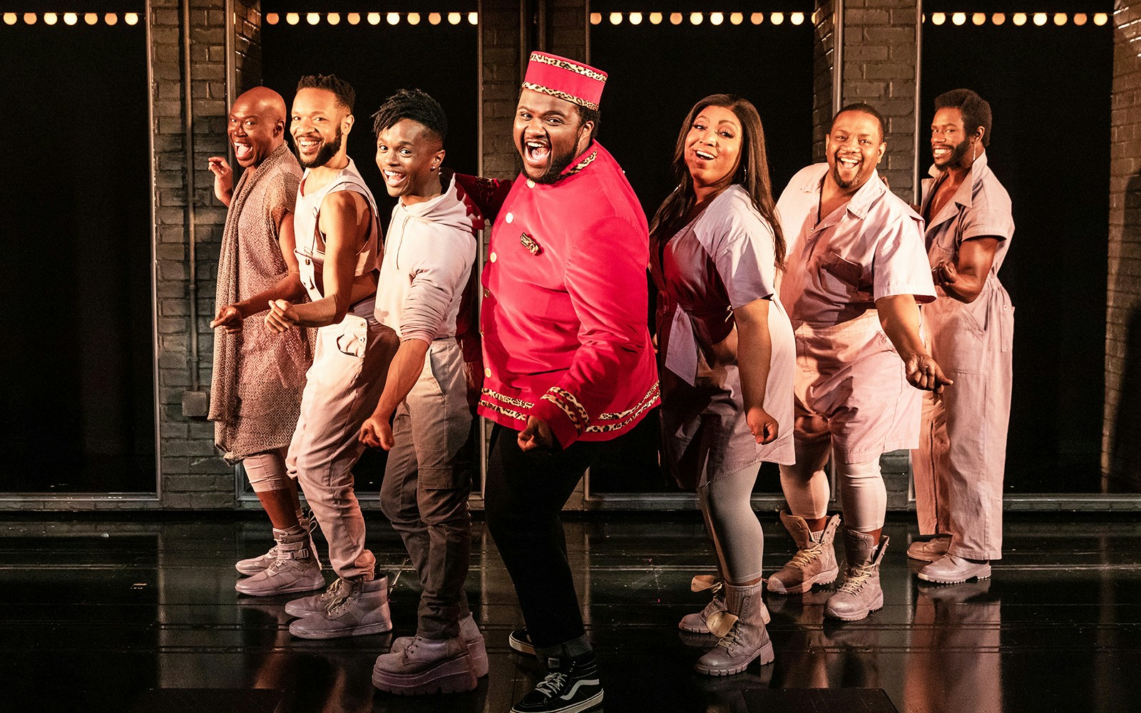 Cast of "A Strange Loop" performing on stage in vibrant costumes.
