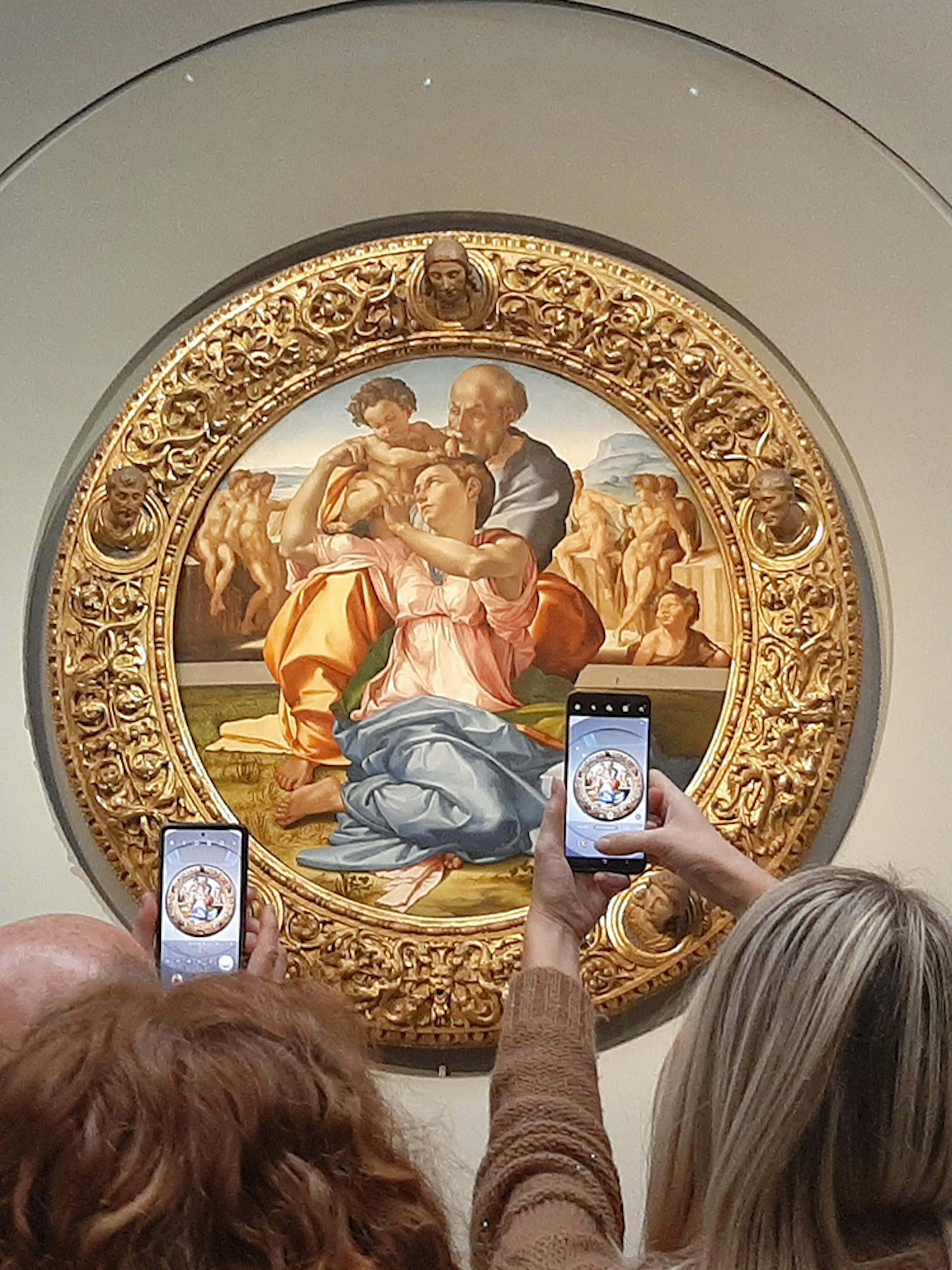 Visitors photographing Michelangelo's Holy Family at Uffizi Gallery, Florence.