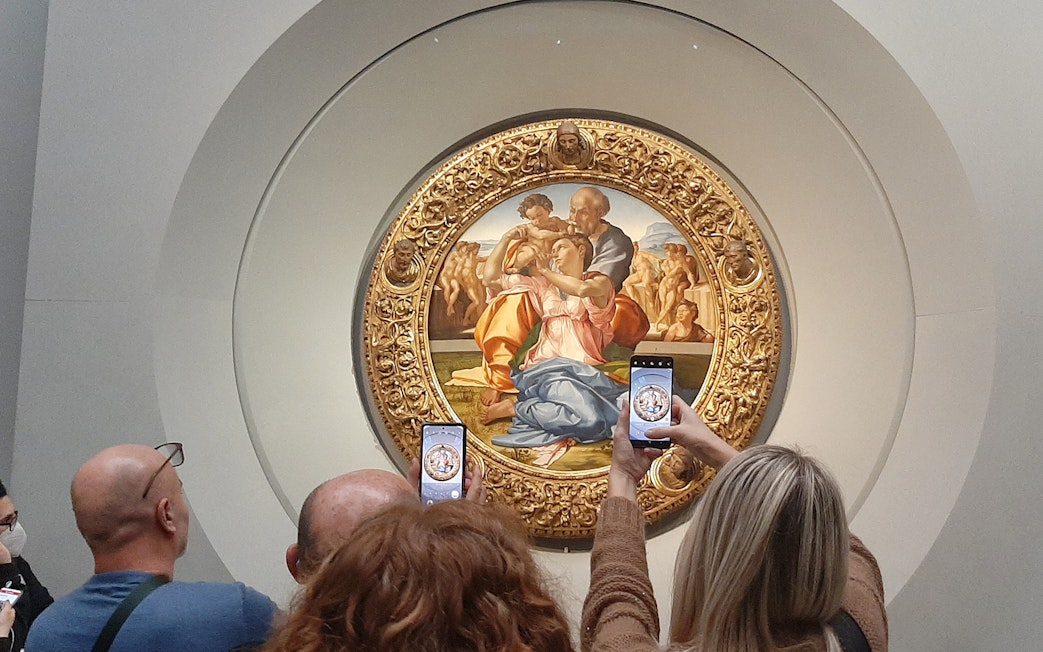 Visitors photographing Michelangelo's Holy Family at Uffizi Gallery, Florence.