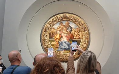 Visitors photographing Michelangelo's Holy Family at Uffizi Gallery, Florence.