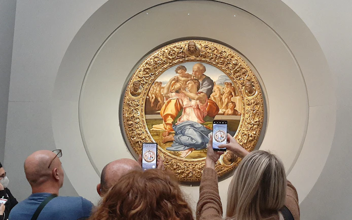 Visitors photographing Michelangelo's Holy Family at Uffizi Gallery, Florence.