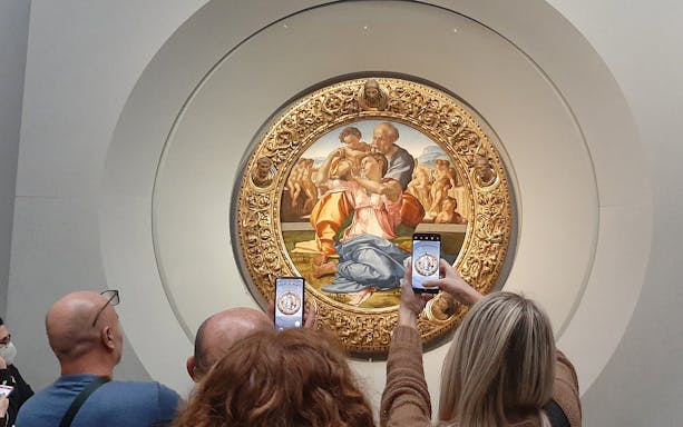 Visitors photographing Michelangelo's Holy Family at Uffizi Gallery, Florence.