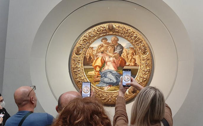 Visitors photographing Michelangelo's Holy Family at Uffizi Gallery, Florence.