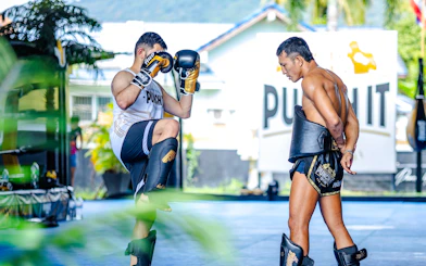 Muay Thai instructor and student practicing kicks in Koh Samui boxing class.