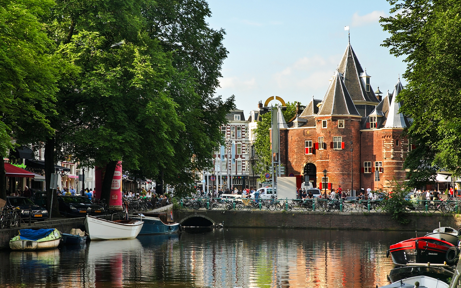 Kloveniersburgwal canal with boats and historic building in Amsterdam.