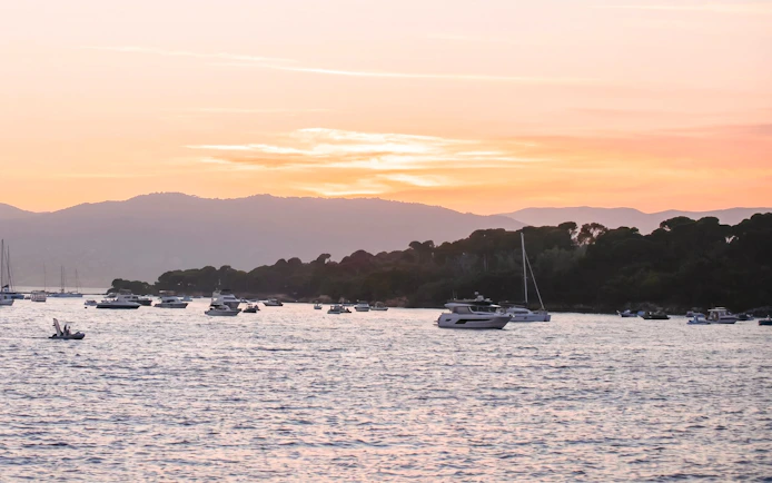 Boats on the water at sunset in the French Riviera.