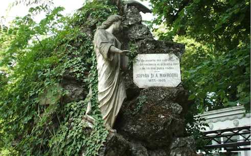 Statue and gravestone of Sophia D. A. Mavrodin at Bellu Cemetery, Bucharest, surrounded by greenery.