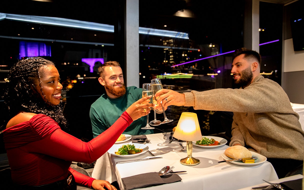 Guests toasting at a Christmas dinner on a Thames River cruise.