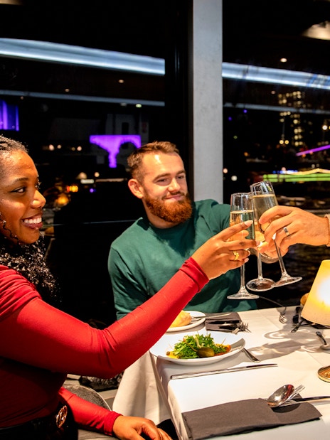Guests toasting at a Christmas dinner on a Thames River cruise.
