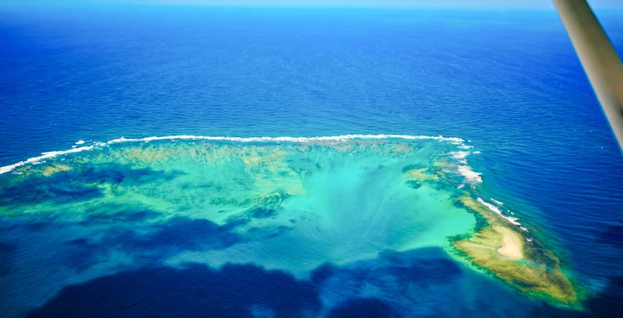 Aerial view of the underwater waterfall illusion near Mauritius on the Eastern Seaplane Tour.