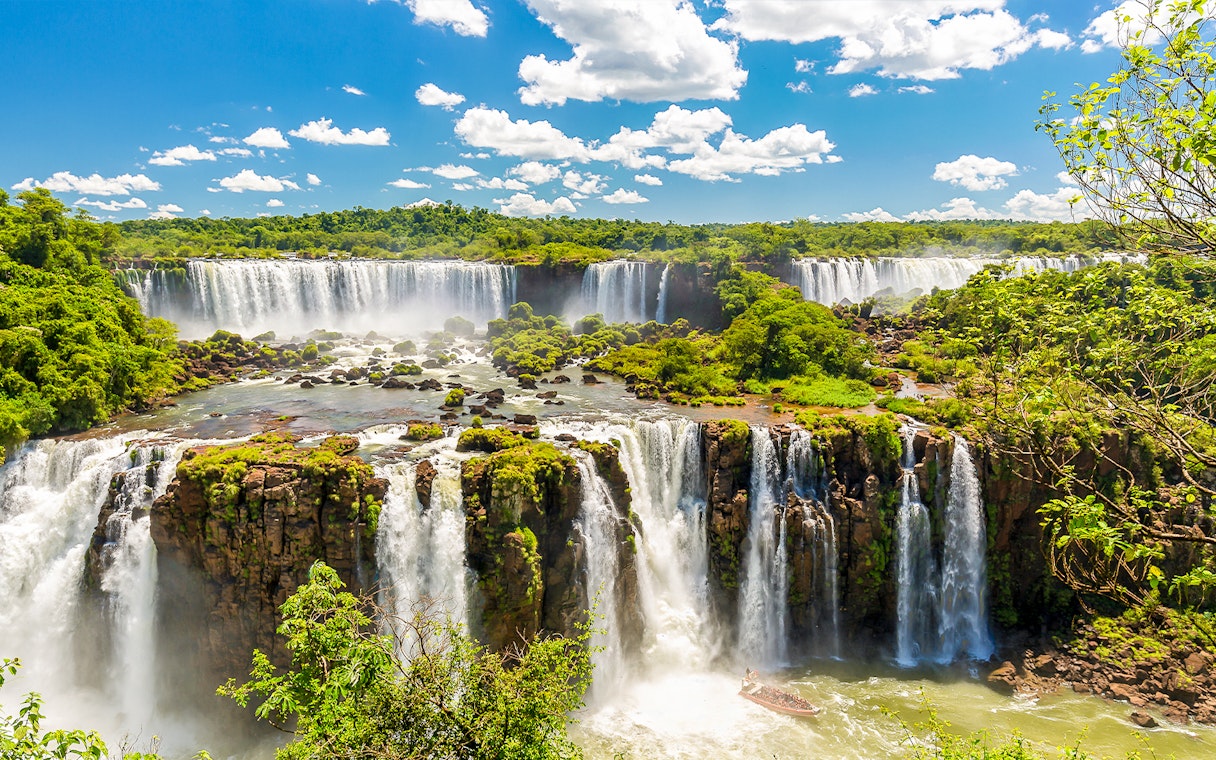 Iguazú Falls cascading over lush cliffs in Argentina.