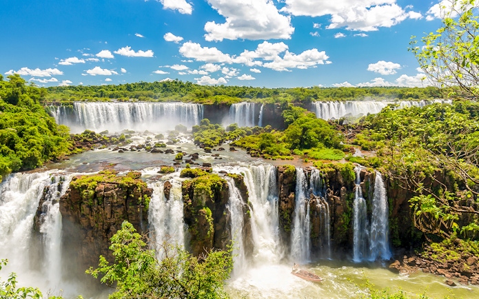 Iguazú Falls cascading over lush cliffs in Argentina.