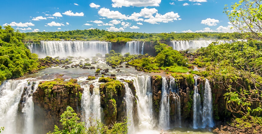 Iguazú Falls cascading over lush cliffs in Argentina.