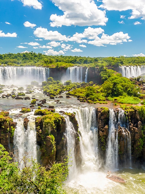 Iguazú Falls cascading over lush cliffs in Argentina.