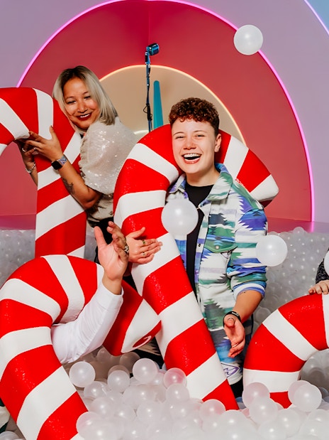 Visitors enjoying candy cane props at The Upside Down Amsterdam exhibit.