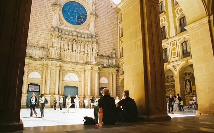 Visitors exploring the courtyard of Abbey of Montserrat, Spain.