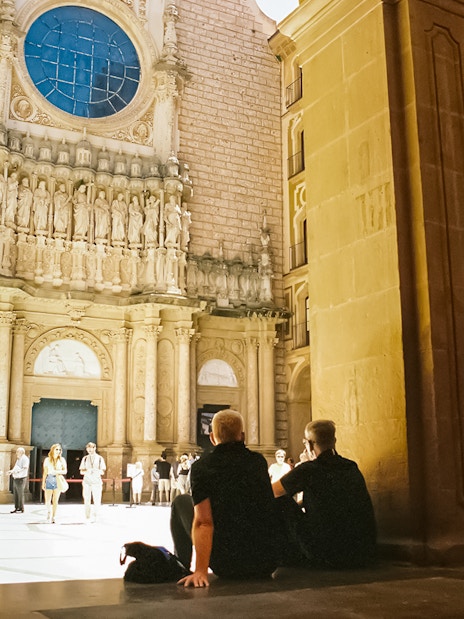 Visitors exploring the courtyard of Abbey of Montserrat, Spain.