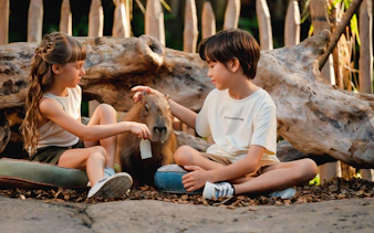 Children interacting with a capybara at Bali Zoo.