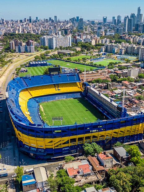 Aerial view of La Bombonera stadium in Buenos Aires, home of Boca Juniors, surrounded by cityscape.