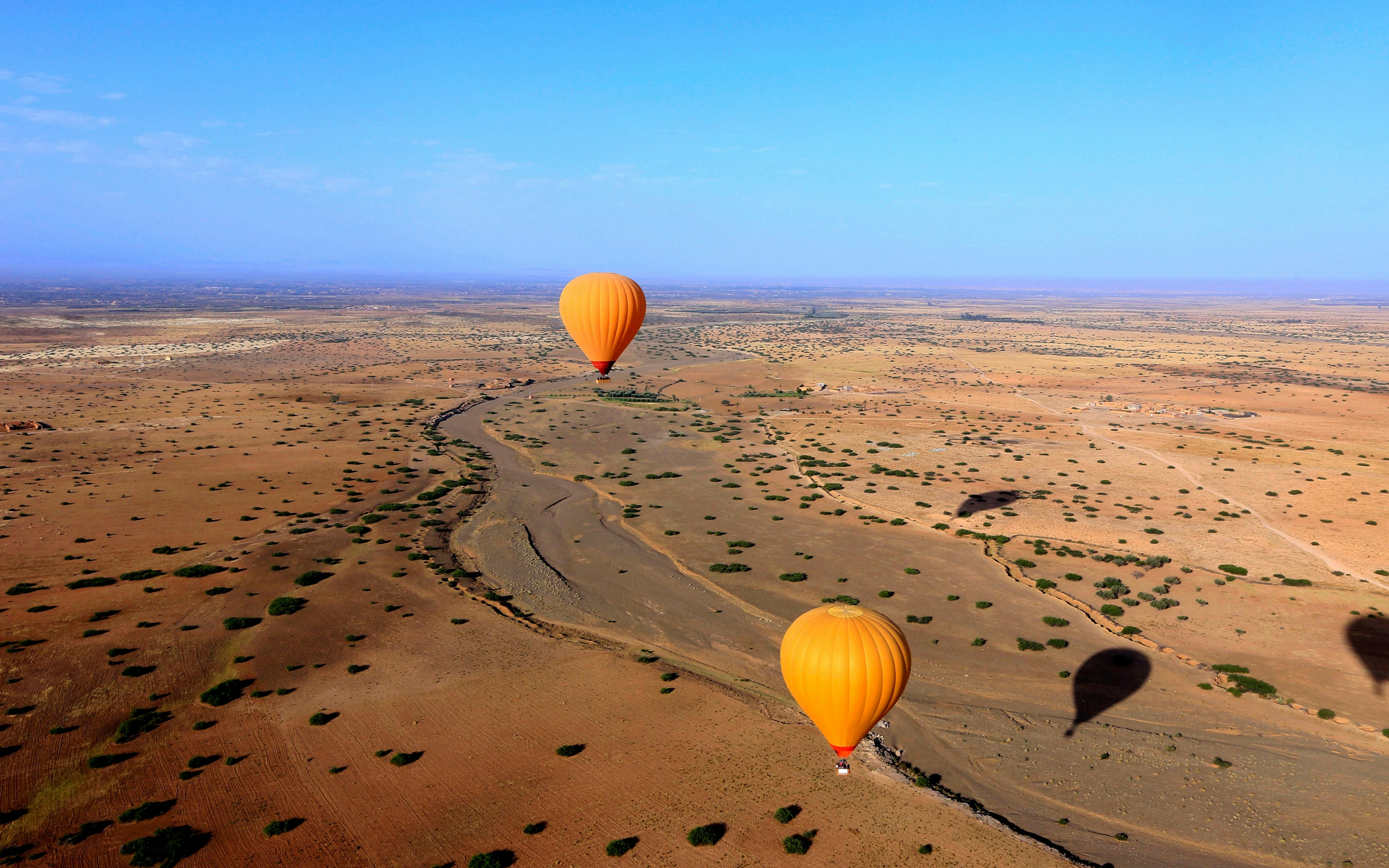 Hot air balloons over desert landscape near Marrakech, Morocco.