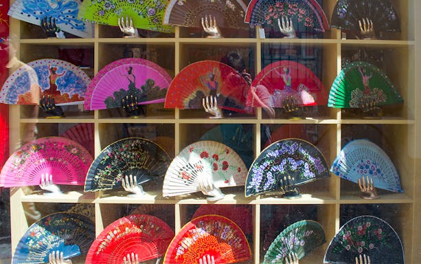 Colorful Spanish fans displayed in a shop window, part of the Salvador church, Casa Pilatos & Metropol Tour.