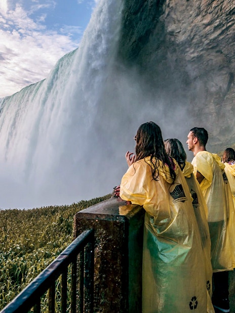 Visitors in yellow ponchos at Niagara Falls viewpoint.