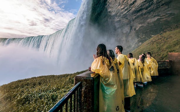 Visitors in yellow ponchos at Niagara Falls viewpoint.