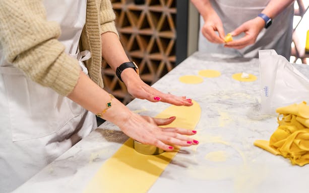 Hands rolling pasta dough in a Florence pasta-making class.