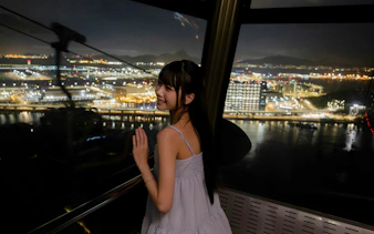Tourist enjoying night view from Ngong Ping 360 cable car on Lantau Island.