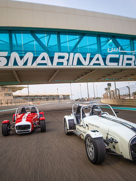 Caterham Seven cars driving on Yas Marina Circuit in Dubai.