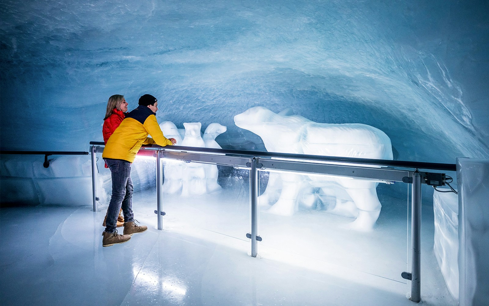 People viewing polar bear ice sculptures in the Ice Palace at Jungfraujoch.