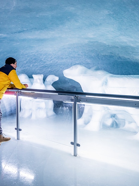 People viewing polar bear ice sculptures in the Ice Palace at Jungfraujoch.