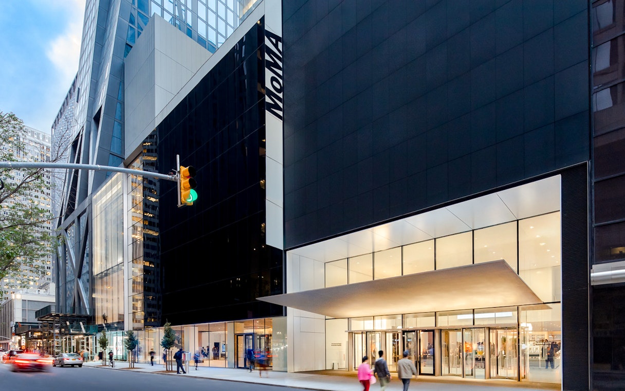 MoMA entrance in New York City with people walking by.