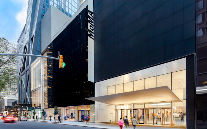 MoMA entrance in New York City with people walking by.