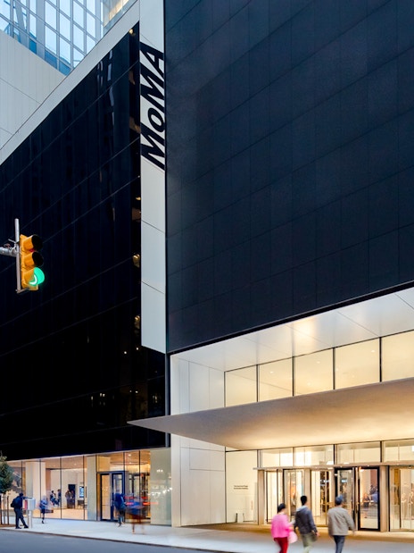 MoMA entrance in New York City with people walking by.