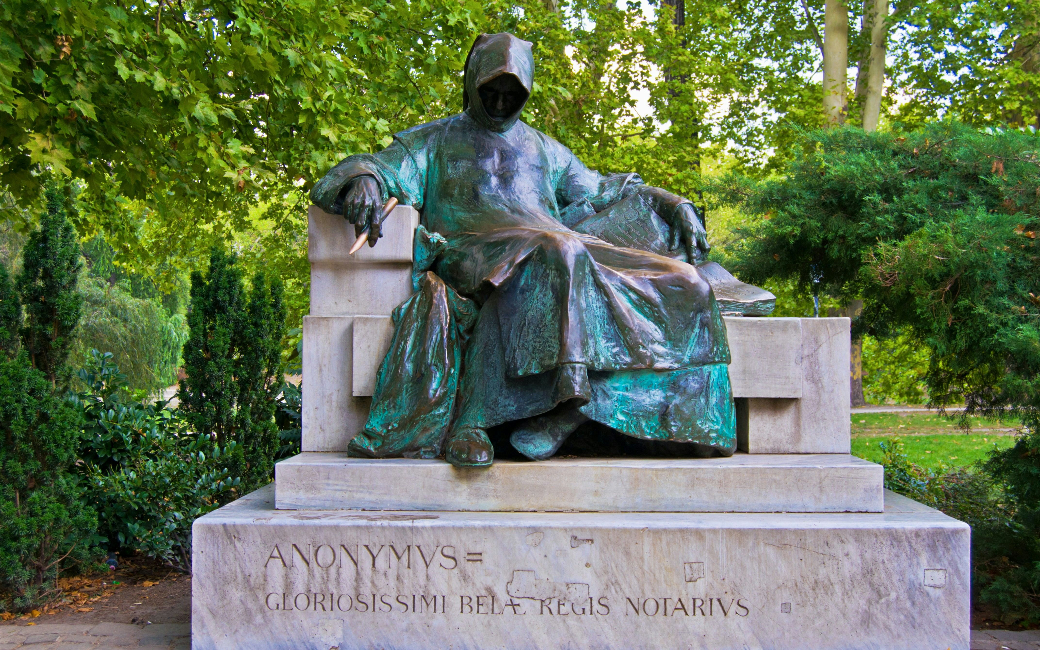 Anonymous statue at Vajdahunyad Castle, Budapest, Hungary, surrounded by greenery.