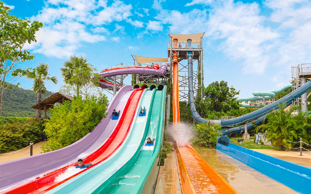 Water slides at Ramayana Water Park with people enjoying rides.