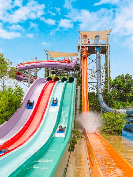 Water slides at Ramayana Water Park with people enjoying rides.